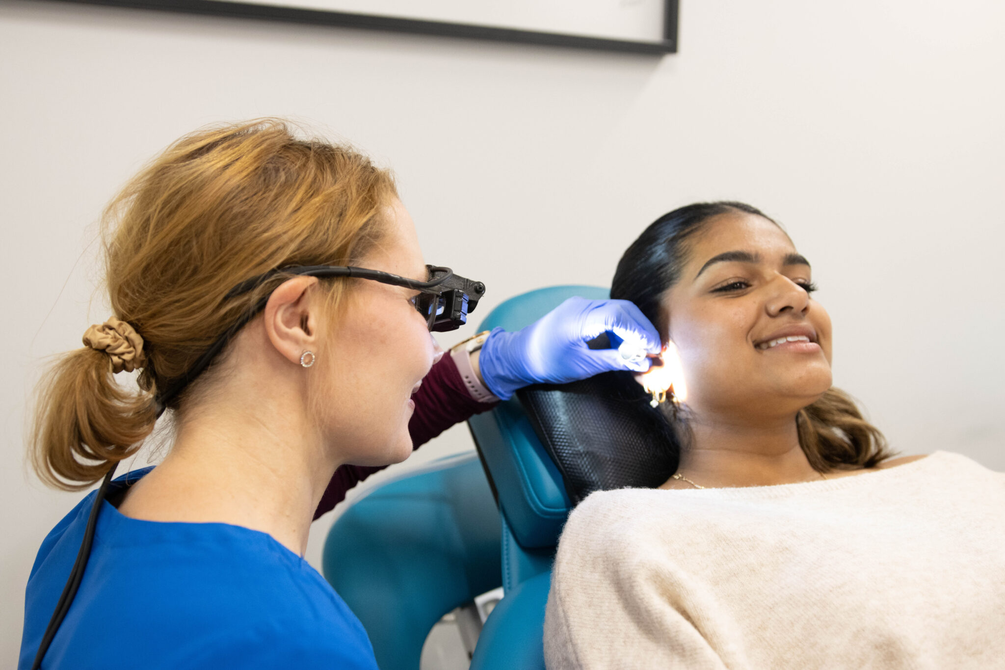 Nurse examining a ear of teenage girl