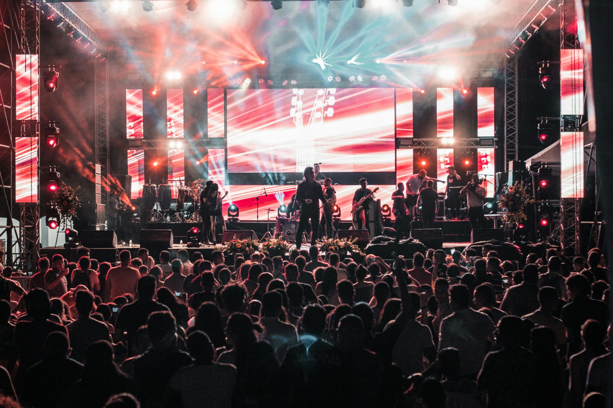 Vibrant outdoor concert event in Santa Marta with a lively crowd and colorful lighting effects.